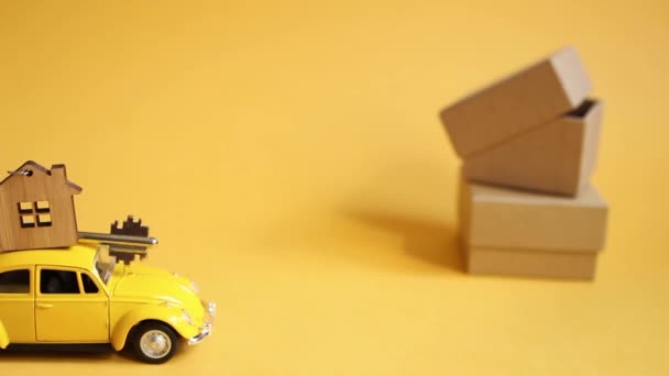 Żółty Samochodzik Kluczem Domu Dachu Idzie Oświetlające Tło Pudełka Przeprowadzka — Wideo stockowe