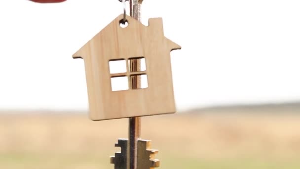 Wooden Pendant House Key Hand Background Sky Field Dream Home — Stock Video