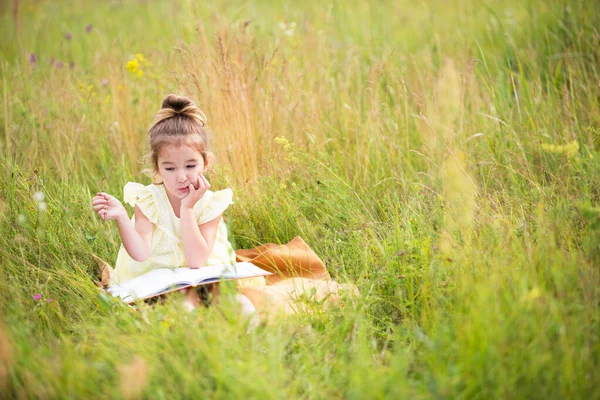 Girl Yellow Dress Sits Grass Blanket Field Reads Paper Book — Stock Photo, Image