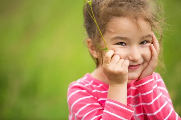 Little Girl Coral Striped Shirt Green Background Field Holds Her — Stock Photo, Image