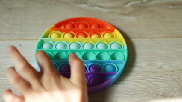 子供は タッチストレス防止シリコーンポップそれおもちゃで再生されます 指は虹色の柔らかい泡とボタンを押す 子供や大人の運動能力とストレス軽減の開発のためのトレンドゲーム — ストック動画