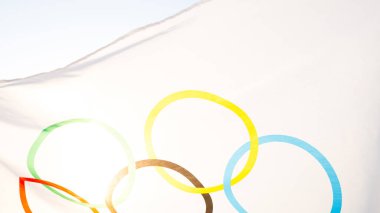 Olimpiyat bayrağı rüzgarda dalgalanıyor gökyüzünün arka planına ve yakın planda güneşe karşı. Olimpiyat Spor Oyunları 'nın sembolü, müsabakaların taraftarı. Kaluga, Rusya, 20 Mayıs 2021 