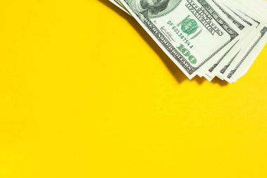 Sarı arka planda 100 dolarlık banknot yığını, 100 dolar. Concept Business, finans, yatırım, nakit ödeme, tasarruf ve zenginlik. Boşluğu kopyala