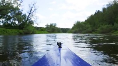 The nose of a kayak on the river-rafting on a sports boat, view from the water. Water hiking, domestic tourism, unity with nature, ecotourism, active recreation, healthy lifestyle, fishing.