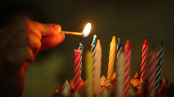父はマッチで娘のためにケーキの上にろうそくを灯す 背景の少女は願い事をして爆破する準備をする 誕生日 記念日 子供の休日パーティー — ストック動画