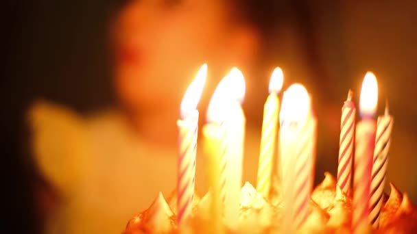 父はマッチで娘のためにケーキの上にろうそくを灯す 背景の少女は願い事をして爆破する準備をする 誕生日 記念日 子供の休日パーティー — ストック動画
