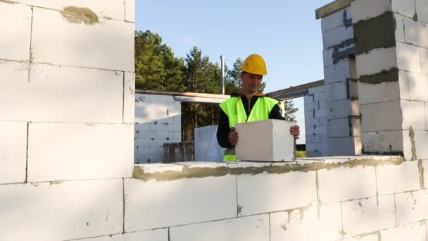 Byggnadsarbetare Byggarbetsplatsen Sätter Muren Ett Hus Luftade Betongblock Skyddskläder Hårdhatt — Stockvideo