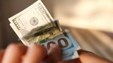 El, 100 dolarlık banknotu yığının içine koyar ve bir banknot alır. Nakit para, 100 dolarlık banknotlar. Finans, ekonomi, mali planlama, ekonomi, tasarruflar.