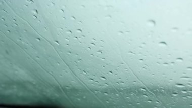 Arabanın ön camından yağmur damlaları aktı. Zor hava koşulları, sonbahar, sınırlı görüş koşulları. Soğuk, nemli, hüzünlü