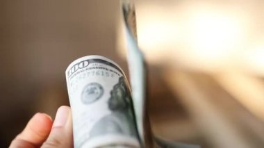 Eller paraları sayar, dolar kaydırır, yelpaze gibi yayılır, banknotları çevirir. Yüz dolar. Yakından 100 dolarlık banknot yığını. Finans, ekonomi, mali planlama, ekonomi, tasarruflar.