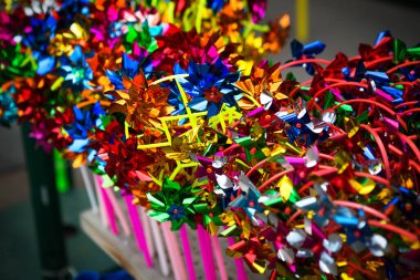 Vitrinde renkli oyuncak yel değirmenleri koleksiyonu. Çocuklar için eğlence