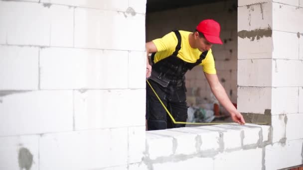 Bauarbeiter Auf Der Baustelle Misst Die Länge Der Fensteröffnung Und — Stockvideo