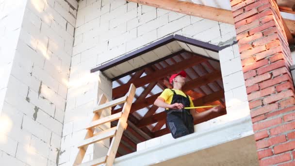 Bauarbeiter Auf Der Baustelle Misst Die Länge Der Fensteröffnung Und — Stockvideo