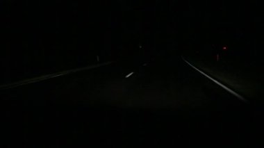 Geceleri otoban, sınırlı görüş koşullarında araba kullanmak. Farlar asfalttaki noktalı yol işaretlerini aydınlatıyor, yaklaşan trafik ışıldıyor. Güvenlik, gece gezintisi, kamyoncu