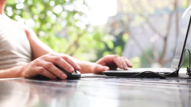 Dışarıdaki avluda dizüstü bilgisayarda çalışan adamların yakın çekimi. Ev ofisi, uzaktan kumanda, uzaktan kumanda. Klavye ve fare kullanarak, rahatla