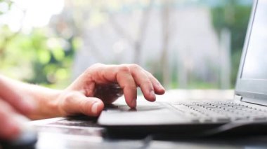 Dışarıdaki avluda dizüstü bilgisayarda çalışan adamların yakın çekimi. Ev ofisi, uzaktan kumanda, uzaktan kumanda. Klavye ve fare kullanarak, rahatla