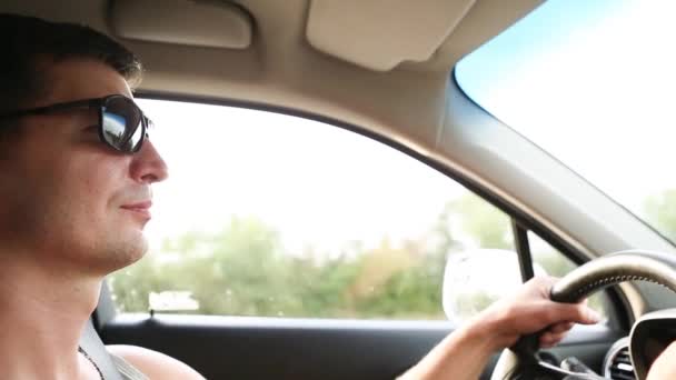 Siyah Güneş Gözlüklü Bir Erkek Sürücü Ellerini Direksiyonda Tutar Otobanda — Stok video