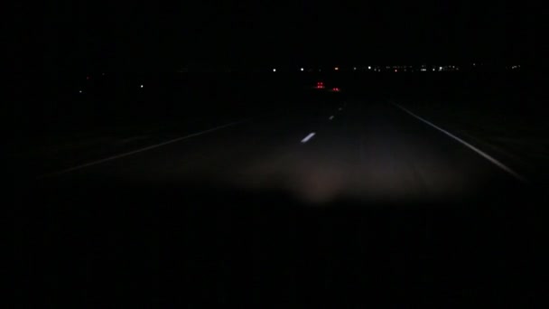 公路在夜间 驾驶在雷雨和有限的能见度条件下 前灯照亮了沥青路面上的斑斑点点 迎面而来的交通让人眼花缭乱 — 图库视频影像