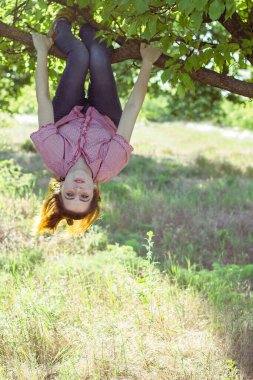 Ağacın tepesinde asılı neşeli kız