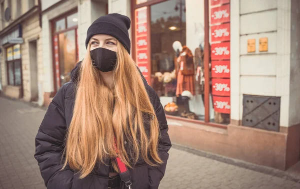 Şehrin sokaklarında koruyucu maskeli bir gencin portresi. Dışarıda uzun saçlı, yakışıklı bir genç. Sağlık hizmetleri