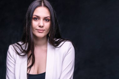 Confident business woman in classic style on dark background. Copyspace