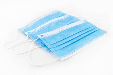Virüse karşı kişisel koruma için üç mavi cerrahi maske, beyaz arka planda izole edilmiş..