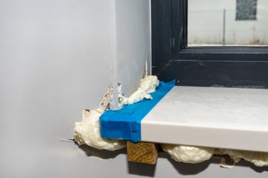 Odanın içine yeni kurulan beyaz holdingin pencere pervazı. Askıya alınmış ve dipten köpükle doldurulmuş..