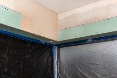 Binanın içinde alçıdan yapılmış dış perdeler için kurulum, pencereler koruyucu folyoyla kaplıdır.