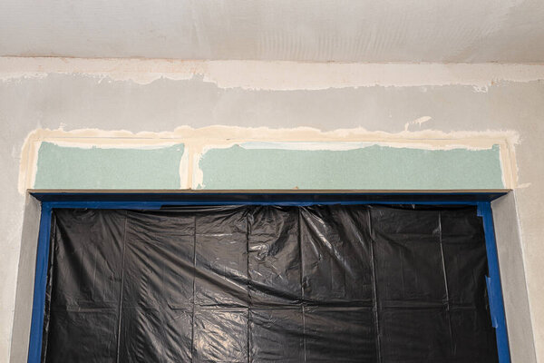 Монтаж наружных рольставней из гипсокартона внутри здания, окна покрыты защитной фольгой.