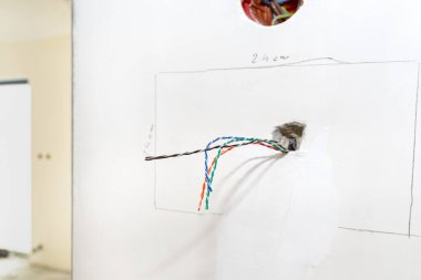 Odadaki duvardan sarkan renkli video telefon kabloları.