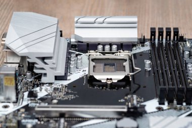 İşlemci için görünen soketi 1200 olan siyah renkli modern bir masaüstü anakart, bellek yuvaları DDR4 ve ısı batar.