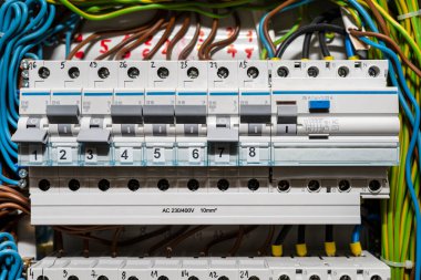 Tek fazlı fünyeler kapalı ve on pozisyonunda ve artık koruma pozisyonu ON pozisyonunda. Bir satırda birçok gri düğme, ev sigortası kutusu.