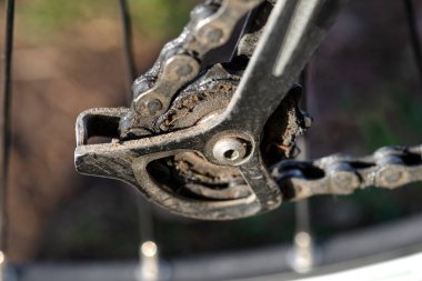 Arka bisikletteki küçük teçhizat raydan çıkmış, yağ bulaşmış, bisiklet zinciri görünür..