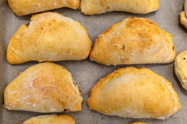 Hamur içinde donmuş hamur köfteleri fırın kağıdının üstünde, en üstte..