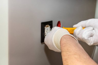 Elektrikçi pencerenin yanındaki odada sarı bir tornavida ile jaluzi kapatıyordu..