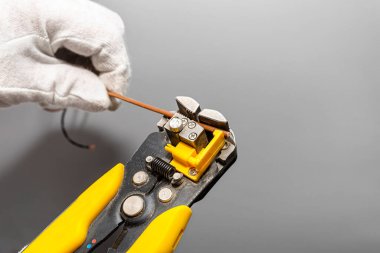 Bir elektrikçi faz kablosunu montaj için otomatik yalıtım striptizcisi kullanır..