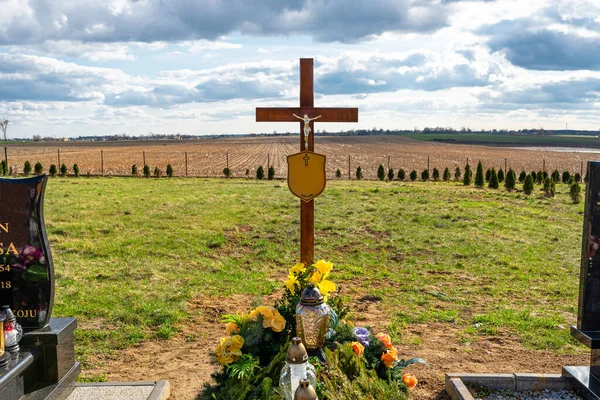 碑文のない名前プレートを持つイエスの姿をした木製の十字架 新鮮な地球の墓の上に立って — ストック写真