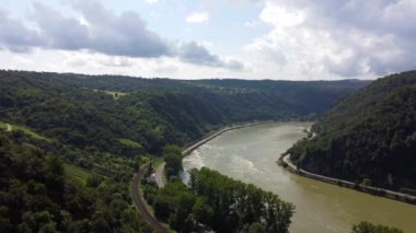 Video from a drone flying above the Rhine river in Germany, visible road on both sides of the river.
