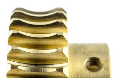 Yeni, parlak bakır bir teçhizatın makro fotoğrafı, beyaz bir arka planda izole edilmiş, kilit vidası için görünür bir delik.