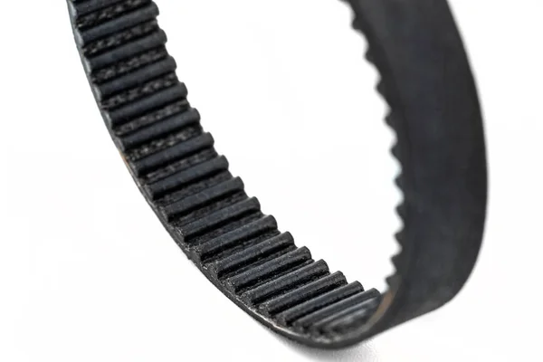 Beyaz arka planda izole edilmiş, dişli bir kemerin makro fotoğrafı..