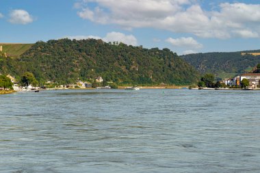 Batı Almanya 'da Ren nehri orman ve görülebilir binalarla kaplı tepeler arasında akar..