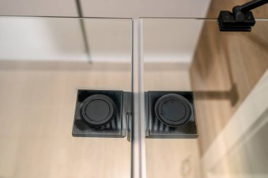 Duşun kanatlarını birleştiren siyah menteşe. Camla sifonu çek, içeriden bak..