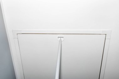 Çatı katına çıkan metal merdivenler, açılmak için bir tüple kapalı kapak, modern görünüş..