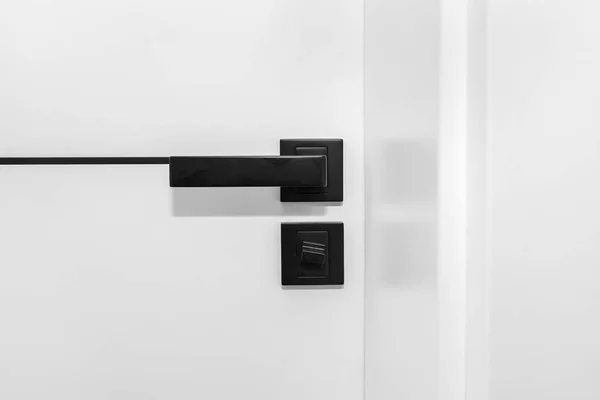 Modern white door with matte black handle and magnetic locks, bathroom door lock.
