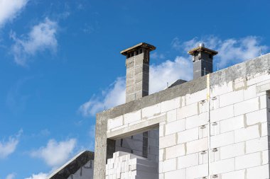 Gable duvarları betonla kaplı, görünür sistem bacaları var..