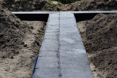 Geniş temel şeritleri siyah dağılım asfalt kauçuk kütle ile boyanmış, gözle görülür beton kolon çubukları.