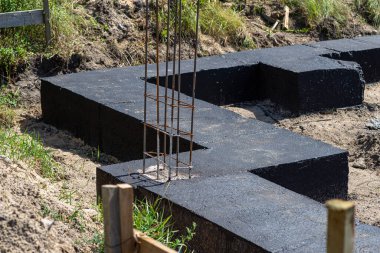 Geniş temel şeritleri siyah dağılım asfalt kauçuk kütle ile boyanmış, gözle görülür beton kolon çubukları.