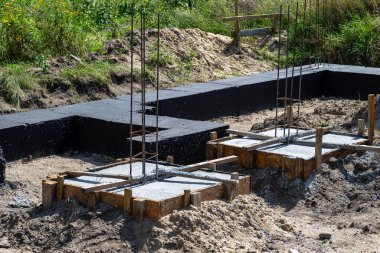 Geniş temel şeritleri siyah dağılım asfalt kauçuk kütle ile boyanmış, gözle görülür beton kolon çubukları.