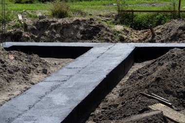 Geniş temel şeritleri siyah dağılım asfalt kauçuk kütle ile boyanmış, gözle görülür beton kolon çubukları.