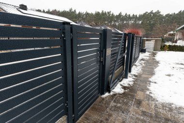 Modern antrasit panel çitleri buz tabakasıyla kaplı..